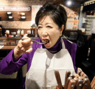 ご飯をほおばる小池百合子氏