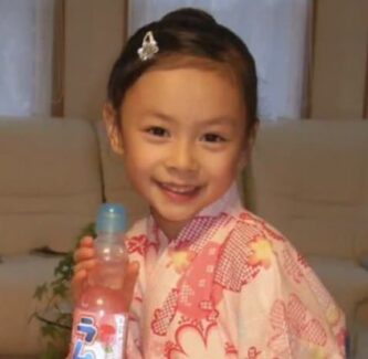 浴衣姿で飲み物の瓶を持って笑う幼少期の伊藤百花さん